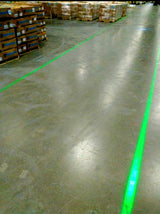 Green DockRight laser line visible in a brightly lit warehouse aisle